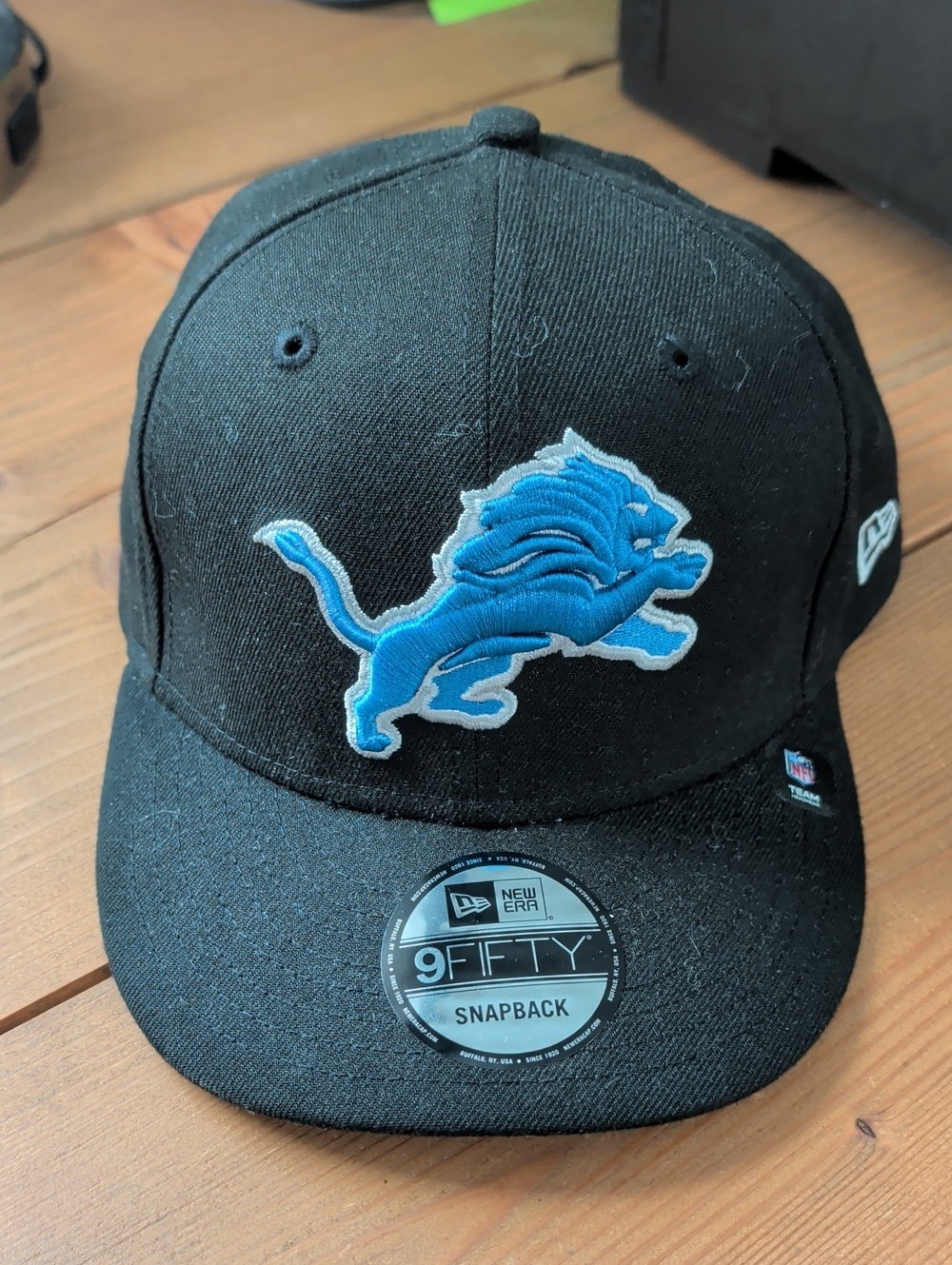 New Era Black Snapback Hat with Blue Lion Patch